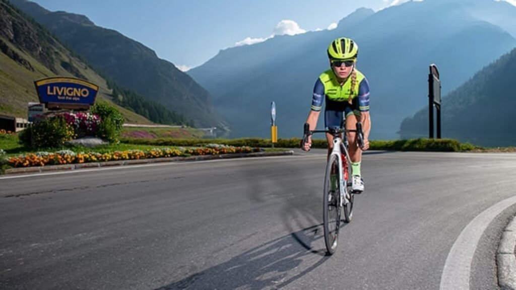 Mujer ciclista subiendo una montaña de Livigno